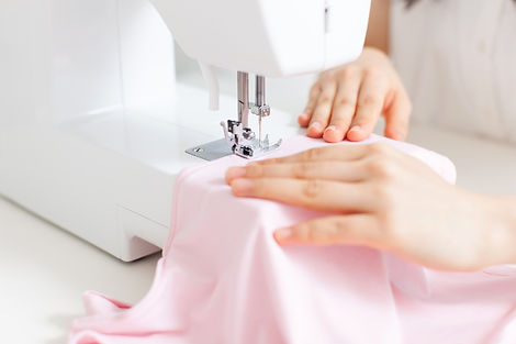 ミシンでピンクの布を縫う様子