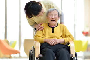 車いすの笑顔のシニア女性と介護士