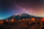 Beautiful view of the milky way over mount Kilimanjaro, Tanzania with many tents at the ba
