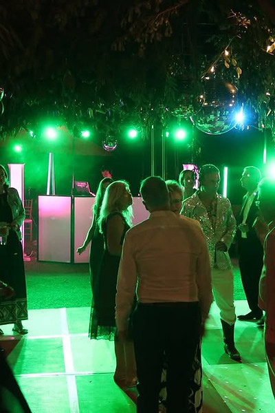 DJ Chapo performing live at a wedding reception with guests dancing.