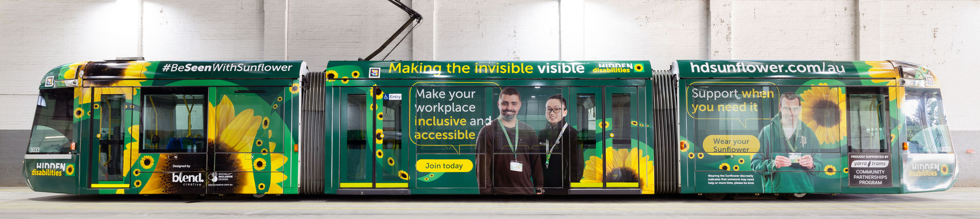 Photograph of a Melbourne CBD tram wrapped in artwork promoting Hidden Disabilities awareness.