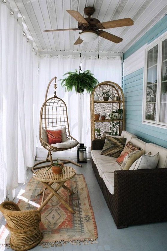 a living room filled with furniture and a hanging chair next to a potted plant