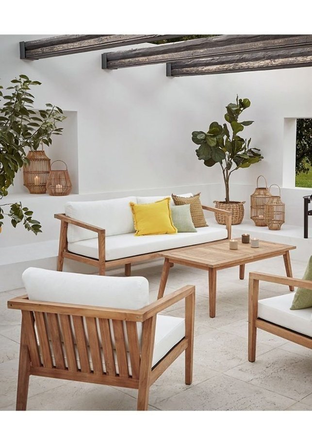 a living room filled with furniture and a potted plant on the side of it