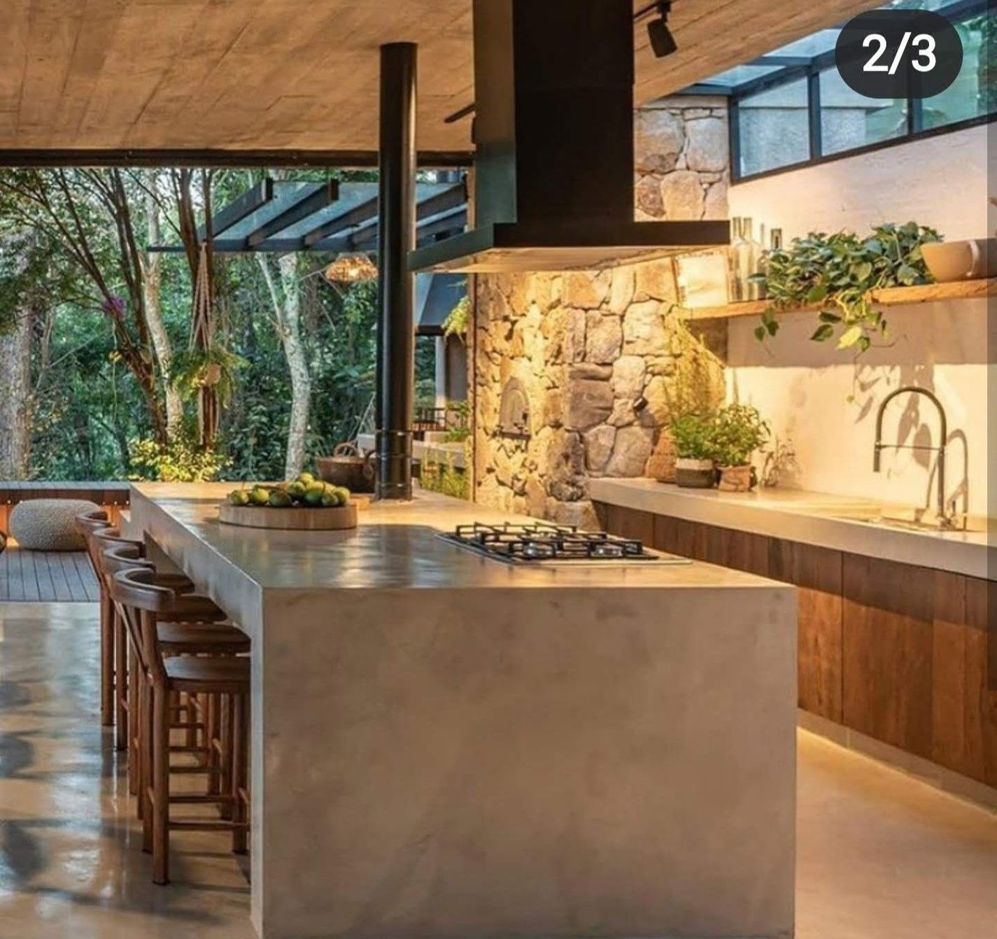 an outdoor kitchen with stone walls and flooring