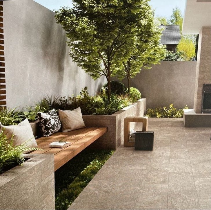 an outdoor seating area with trees and plants on the wall