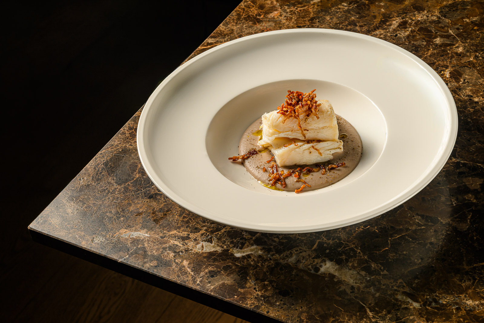 Baccalà in porchetta creativo su crema di fagioli al rosmarino