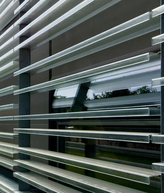 dettaglio in primo piano della facciata ventilata. In primo piano si vedono i particolari delle lastre orizzotali che percorrono tutta la facciata dell'azienda.