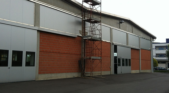 Capannoe prima della trasformazione in ristorante. Il capannone era una carrozzeria di mattoni, con un portone basculaante. La parte alta aveva delle strutture in metallo che accoglievano dei vetri oscurati da delle pellicole