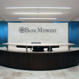Corporate reception area with branded feature wall, curved reception desk, and contemporary interior finishes at Bank Midwest headquarters.