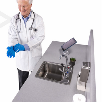 Healthcare professional installing a stainless steel sink into a medical office countertop.