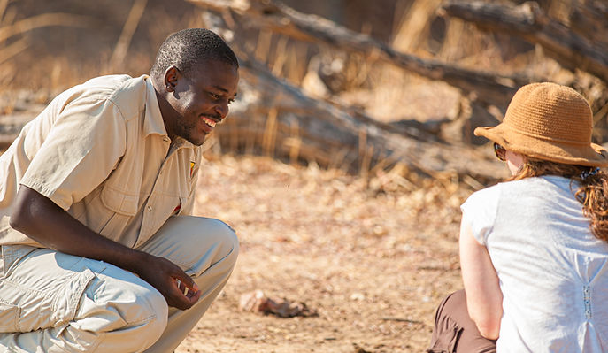 A safari guide smiling and talking to a woman