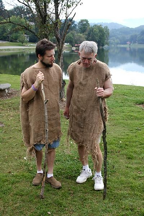 Photograph of an older man and a younger one, both dressed in sackcloth, standing on a green lawn before a lake, illustration for a study on the Two Witnesses prophesying 1,260 days dressed in sackcloth.