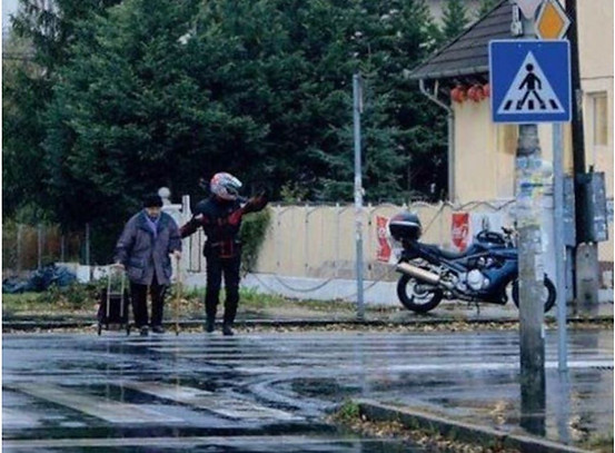 Photo of man helping elderly person across the street, for Kindness lasts forever, with fourteen examples in pictures.