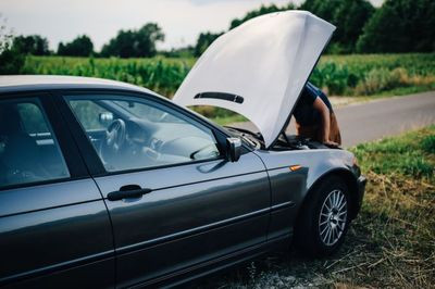 car repair, broken down, broken down car, man fixing car, roadside assistance, under the hood, old car, hubcap, engine problems