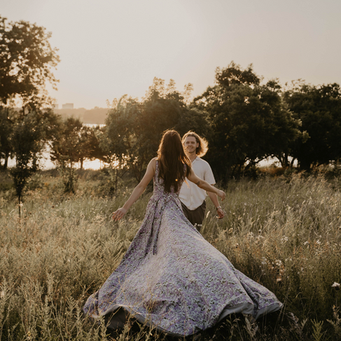woman in flowing flowery dress in field of wildflowers