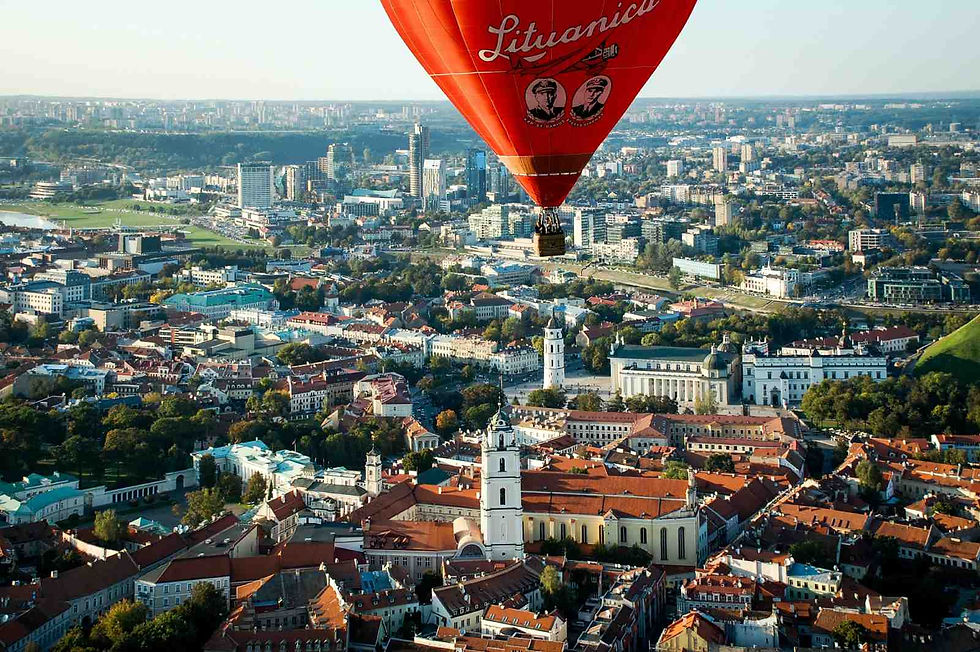 an aerial view of the city of Vilnius in Lithuania, with a hot-air balloon in the foreground
