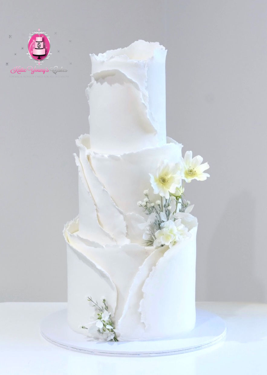 3 tier white ruffle fondant cake with cosmos flowers