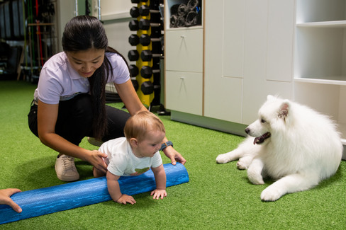 An infant practicing crawling with a female physiotherapist.