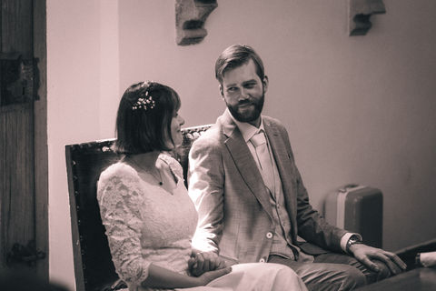 bruidegom kijkt liefdevol naar zijn bruid in deze sfeervolle trouwfoto.