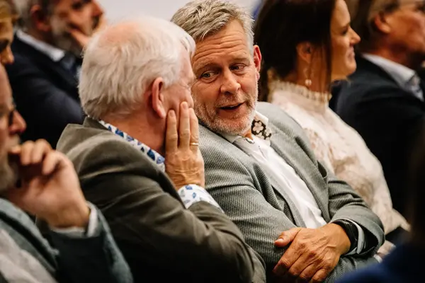 Twee zakelijke gasten in geanimeerd gesprek tijdens een evenement in Amsterdam.