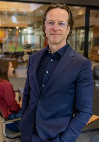 Zakelijk portret van man in blauwe blazer in kantooromgeving – portretfotograaf Rotterdam