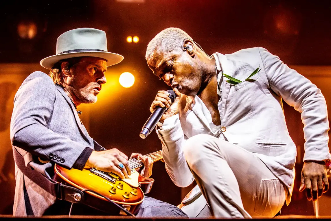 Two musicians play together during a live performance on a festival stage