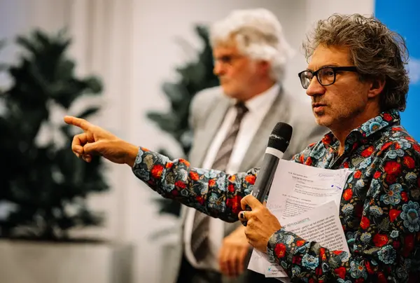 Een spreker in gesprek tijdens een netwerkevenement in Rotterdam, sfeervol in beeld gebracht door Willem Martinot.