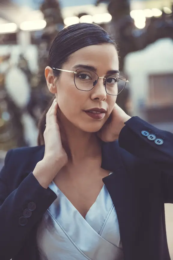 Woman with glasses looks over shoulder in campaign photo