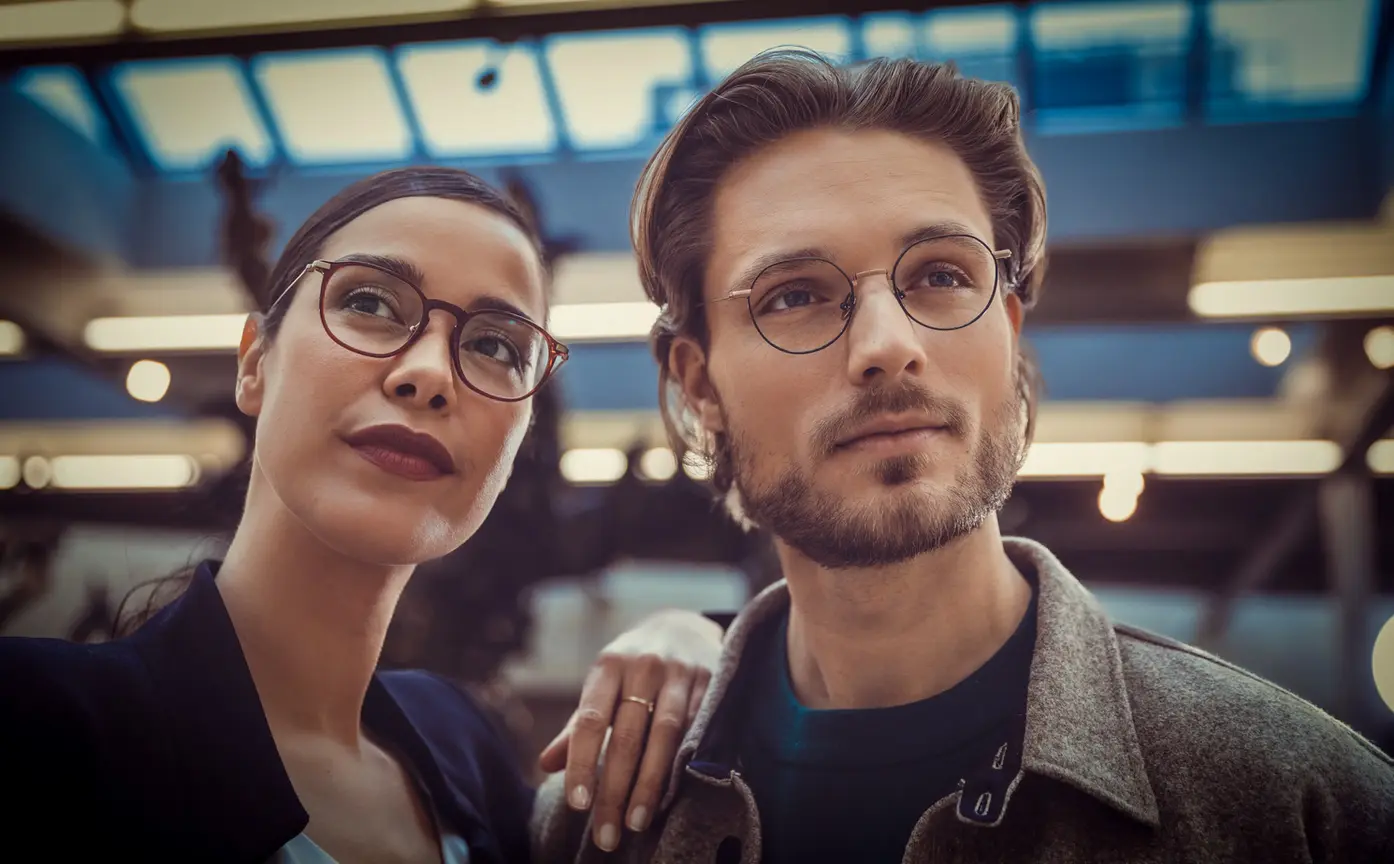 Man and woman with glasses in urban setting in evening light