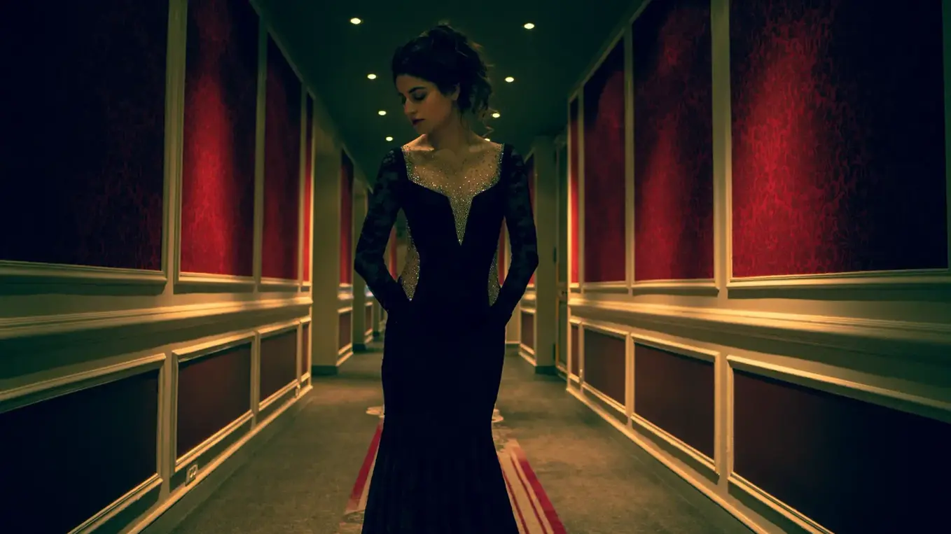 Model in black evening dress in long hallway with symmetrical lines