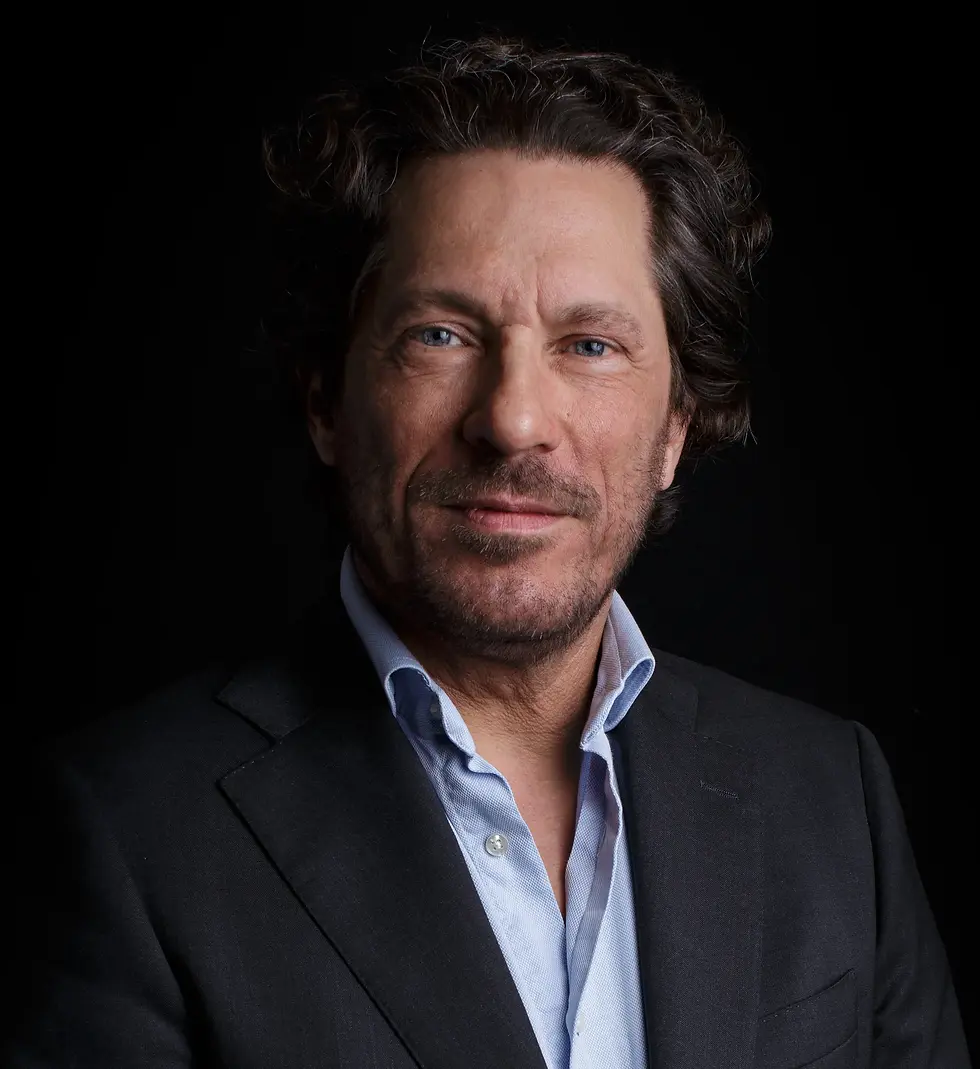 Portretfotografie van een zakenman met donkere achtergrond en zacht licht.