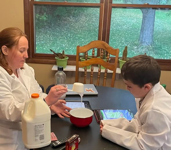 Meagan demostrating science concept to elementry student during tutoring session. 