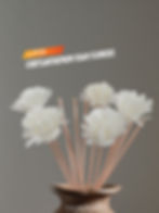 Chrysanthemum foam flower placed on top of diffuser reeds in a decorative vase