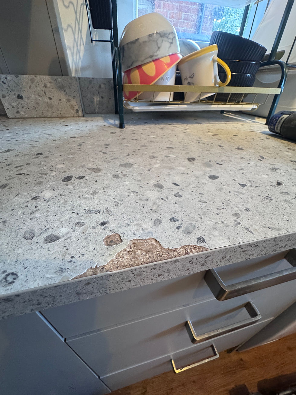 Front edge of a grey terrazzo-effect laminate worktop in Chester, burnt and swollen down to the chipboard