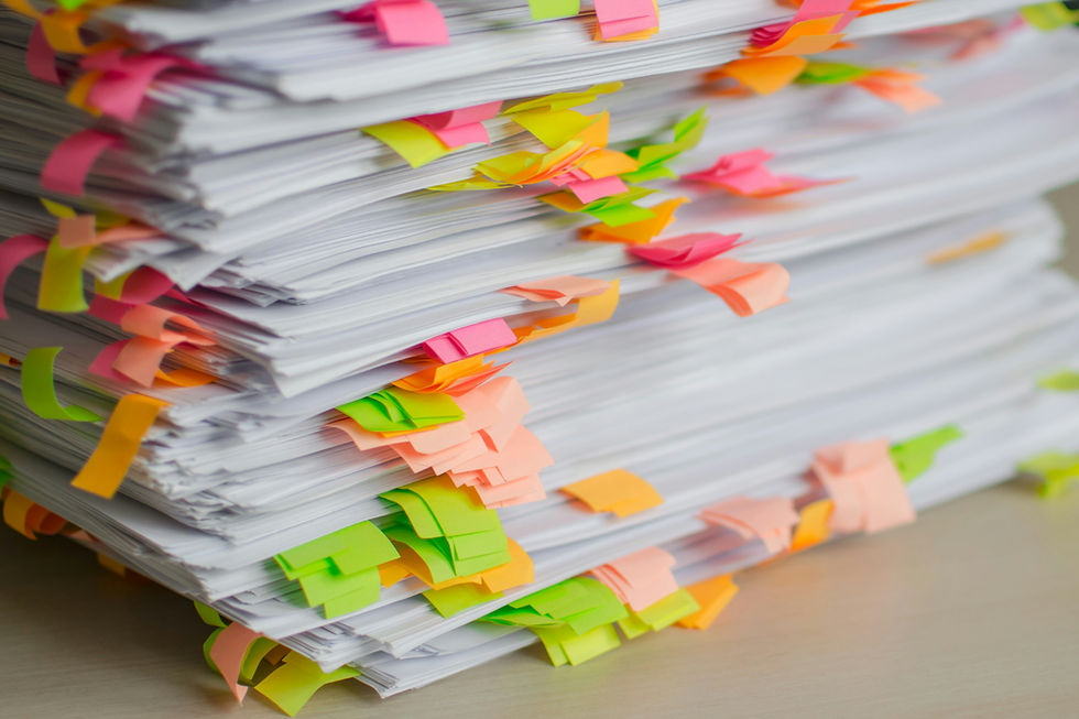 Tall stack of home-selling disclosure paperwork flagged with colorful sticky tabs, ready for a seller to review and sign