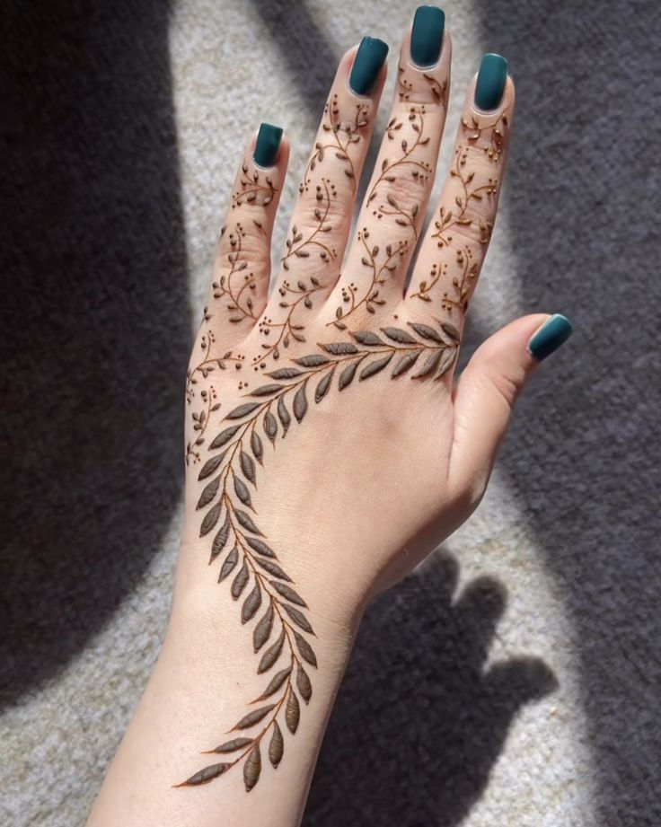 vines and leaves mehndi design on left hand with green nailpaint on the nails