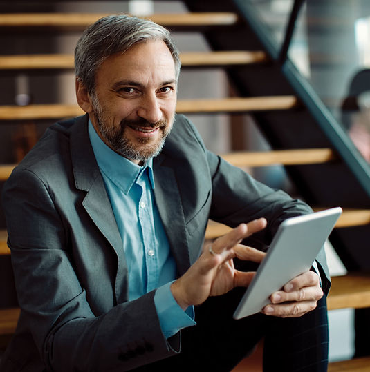 happy-businessman-using-touchpad-while-relaxing-staircase-looking-camera (1).jpg