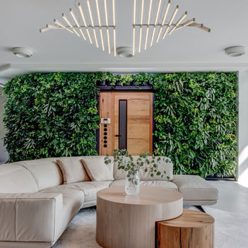 Interiér obývacího prostoru s přírodními materiály a zelenou stěnou