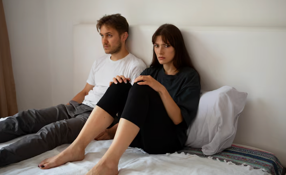 Couple sitting together with emotional distance and disconnection in their relationship
