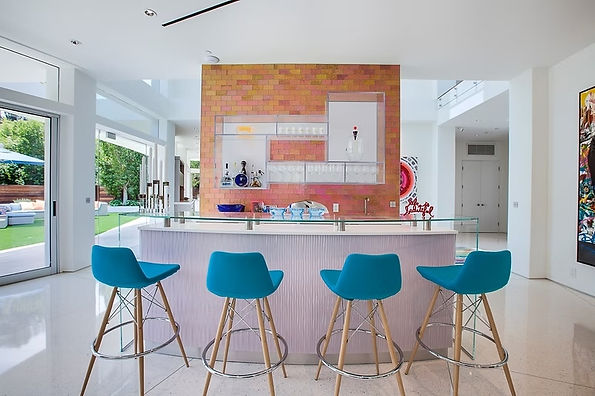 Contemporary bar with turquoise stools, a curved counter and a warm metallic feature wall.