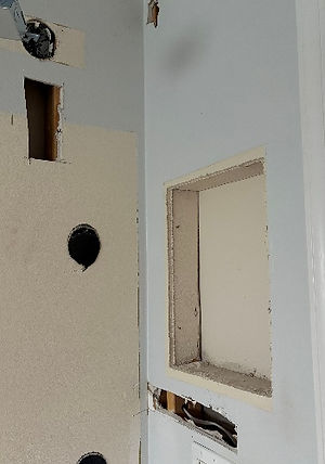 Land O’ Lakes bathroom before repair, showing medicine cabinet opening and fixture holes