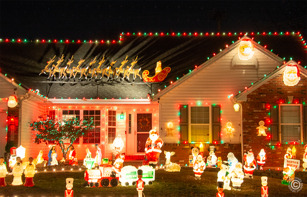 Christmas lights and blow molds all over a house and yard.