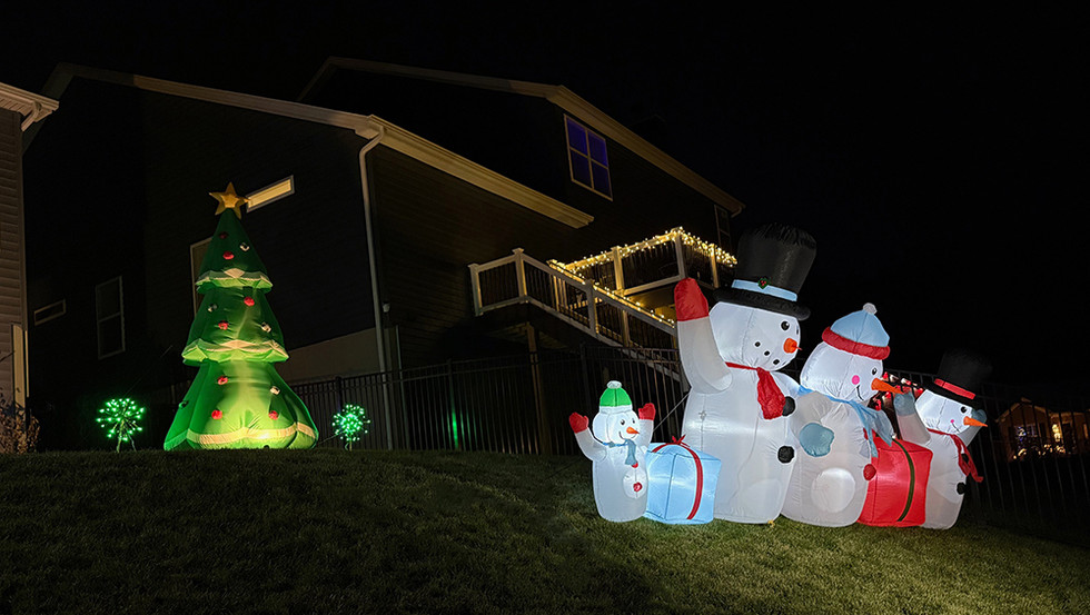 Snowmen lighting up the hill behind the house.