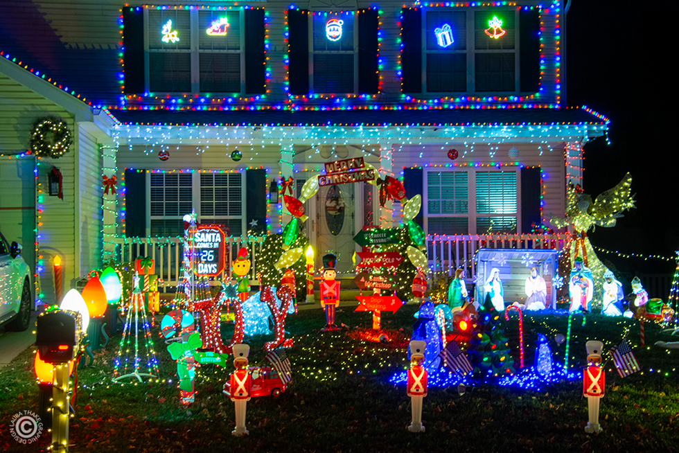 Adorable Christmas blow molds and lights covering a house and yard.