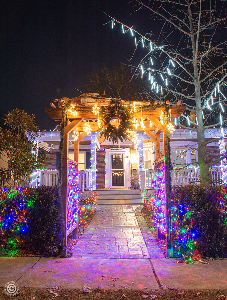 The gazebo is all lit up and covered in garland.