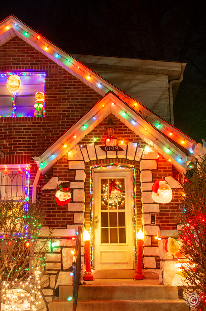 Santa greets you at the front door that is surrounded by lights.