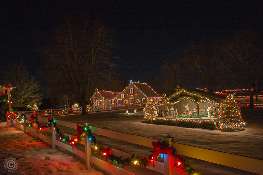 A Christmas manger scene with the farmhouse in the background.