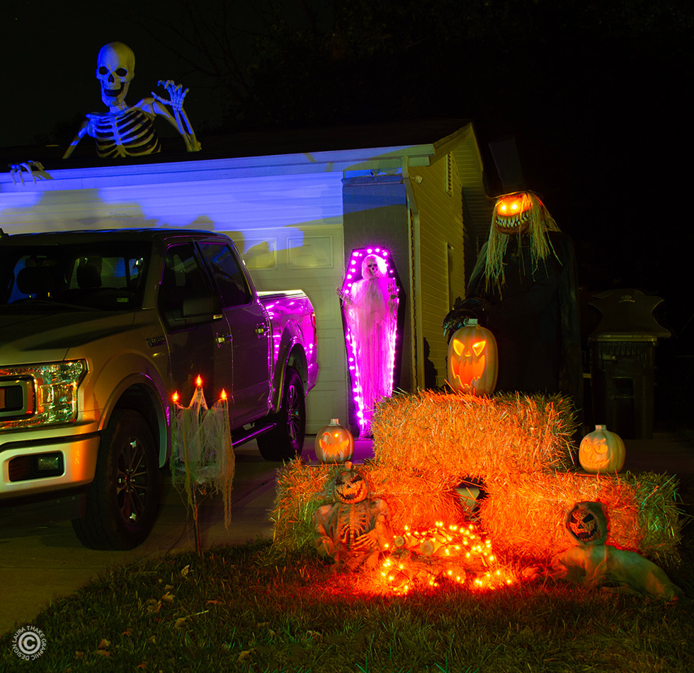 The Earth Mover skeleton is on the roof, and pumpkins and hay bales in front.