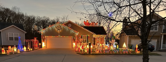 The whole house lit up for Christmas from the tip of the roof to the edge of the curb.