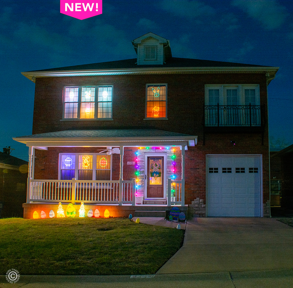 A large two story brick house with Easter lights in all the windows and around the front door.